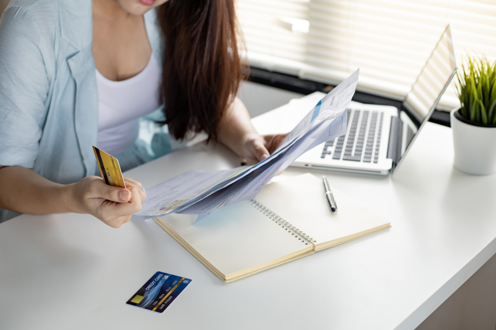 Woman holding a credit card and bill